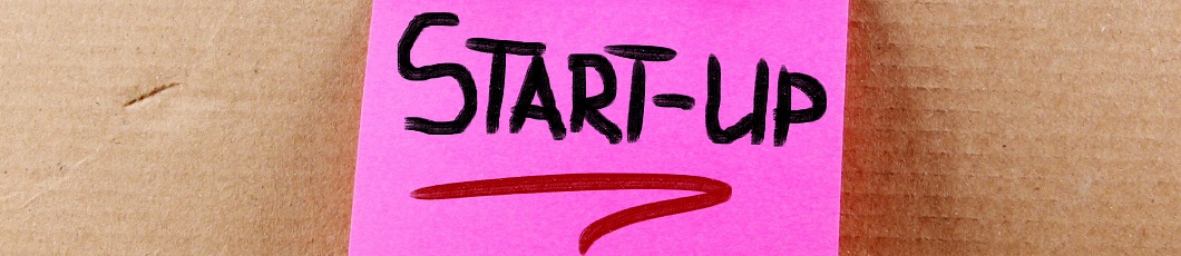 Pinkes Post-it auf Korkwand mit Aufschrift:"Start-up"